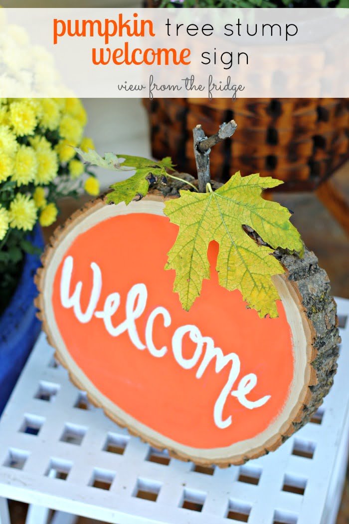 A Friendly Pumpkin Tree Stump Sign Says “Welcome”