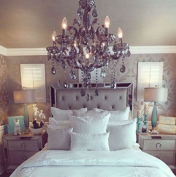 A Grey Chandelier and Satiny Bed Settings Give this Bedroom a Regal Feel